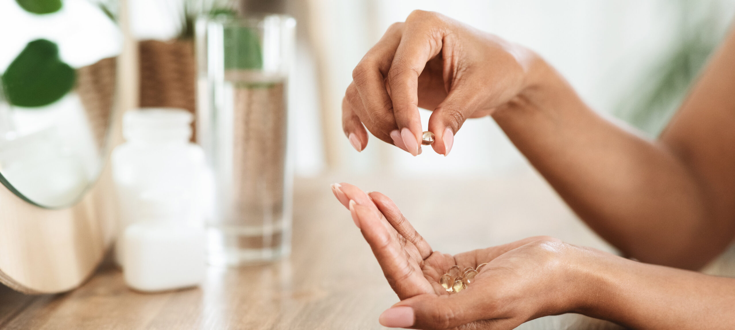 A woman at home holding a few vitamins