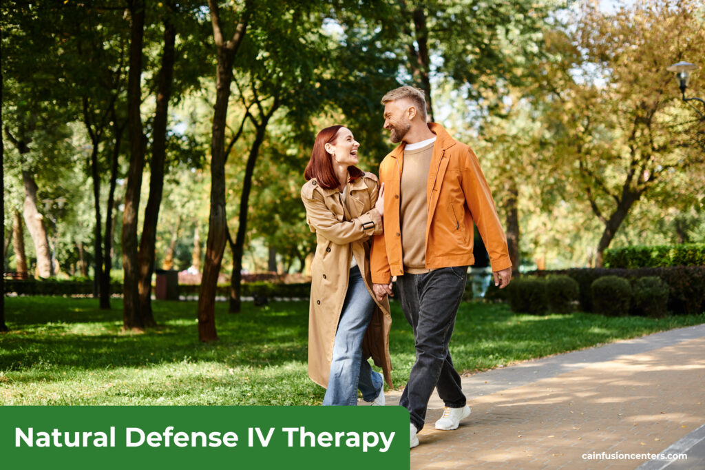 Smiling couple walking outdoors in a park, feeling energized and balanced after Natural Defense IV Therapy from California Infusion Centers in Arcadia.