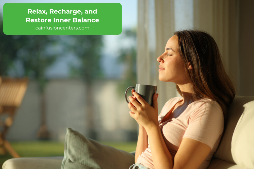 Woman relaxing with a cup of tea in natural light symbolizing comfort and post-infusion recovery.