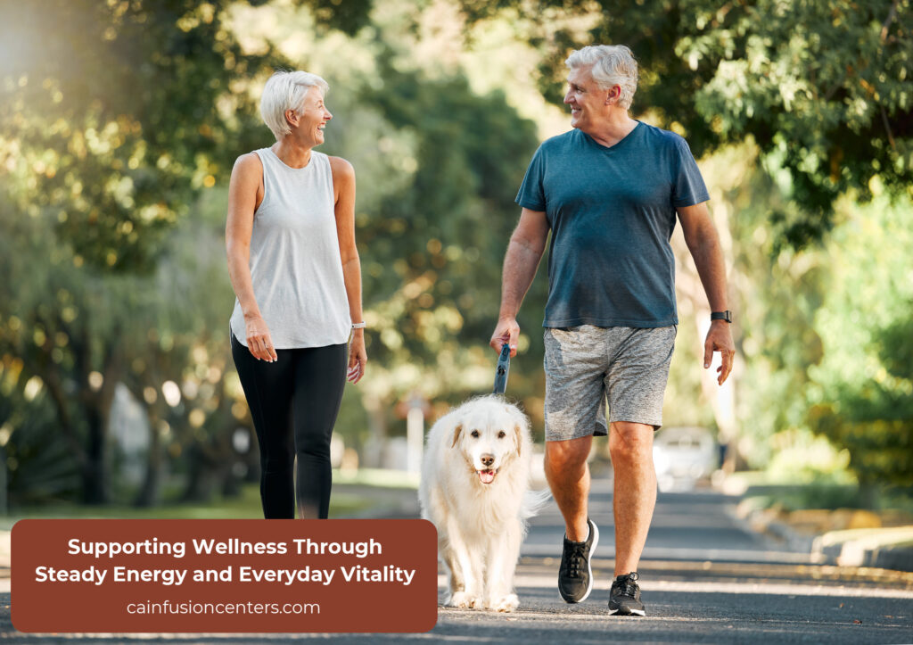 A smiling older couple walks their dog through a sunny neighborhood path, reflecting improved energy and daily vitality after iron support.