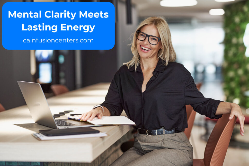 Smiling professional woman at a desk with laptop, representing improved mental focus and productivity after IV therapy.