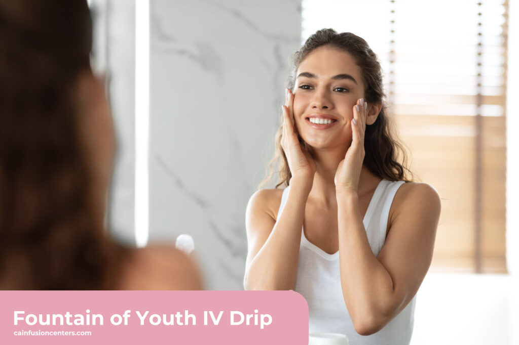 Smiling woman touching her face in the mirror with healthy, radiant skin after receiving Fountain of Youth IV Therapy from California Infusion Centers in Arcadia.