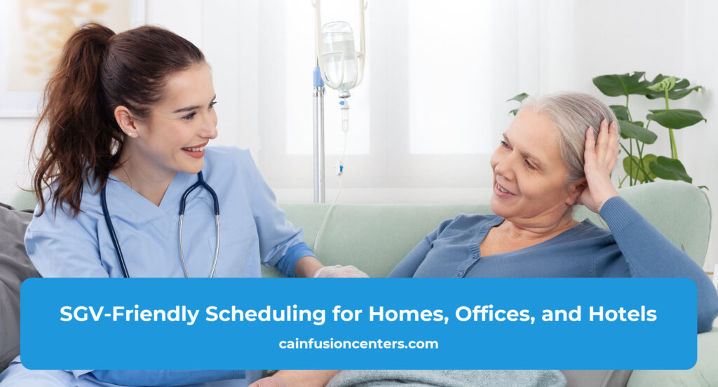 A patient relaxes in a comfortable chair at home while a nurse monitors an IV drip on a stand.
